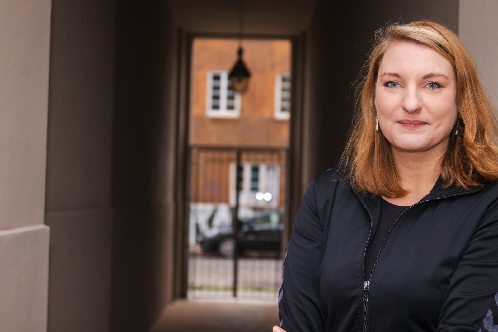 Foto zeigt ein Portrait von Isabelle Vandre vor einem Hausdruchgang.